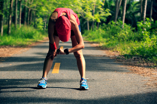 Fiatal fitness nő runner, pihenő- és ellenőrzése a sportóra  - Fotó, kép