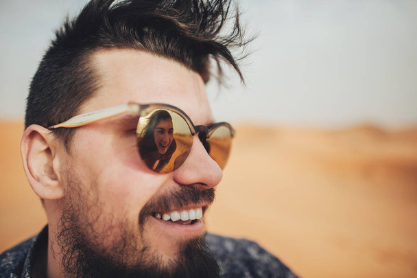 man in sunglasses with reflection of young woman - Foto, imagen