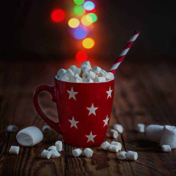 Red cup of hot cocoa with marshmallows and candy canes a colorful bokeh background with beautiful Christmas lights - Foto, Imagem