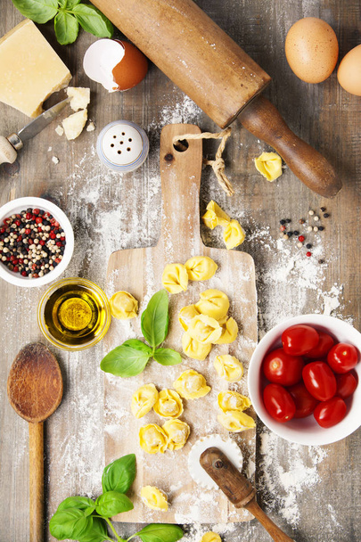 raw italian pasta tortellini on wooden board - Zdjęcie, obraz