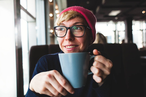 Portret van een lachende meisje met koffie - Foto, afbeelding