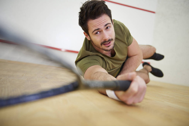 Jogador alcançando a bola de squash
 - Foto, Imagem