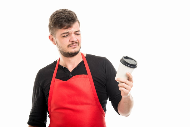 Supermercato maschile datore di lavoro guardando strano a tazza di caffè
 - Foto, immagini