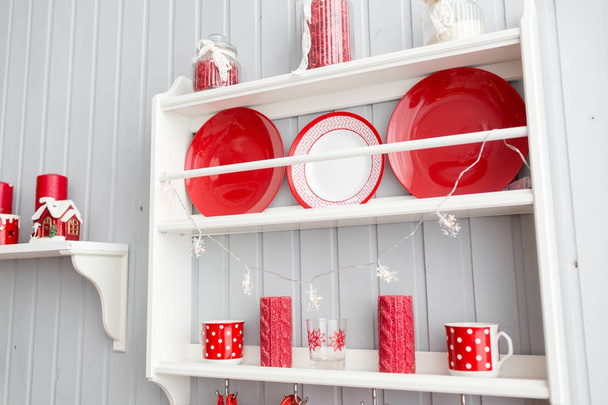 schappen met gerechten. Interieur licht grijze keuken en rode kerst decor. Voorbereiding van de lunch thuis op het concept van de keuken. - Foto, afbeelding