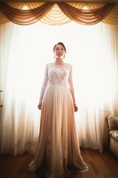 beautiful young bride near the window in full growth - Foto, Imagem