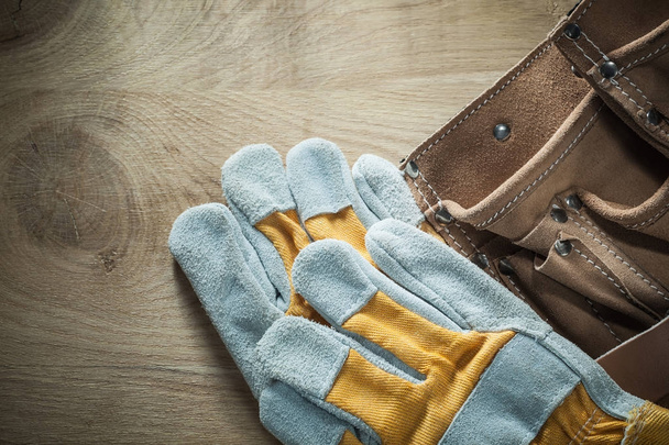 Leather building belt safety gloves on wooden board - Zdjęcie, obraz