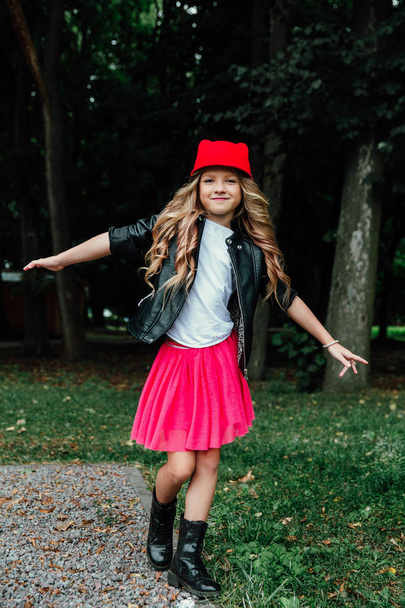 Outdoor lifestyle portrait of stylish little girl teenager on city park. . Beautiful child, wearing. - Zdjęcie, obraz