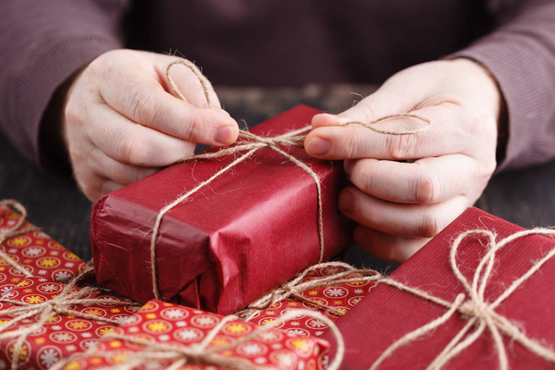 Process of package and wrapping Christmas and New Year gift box with man hands - Valokuva, kuva