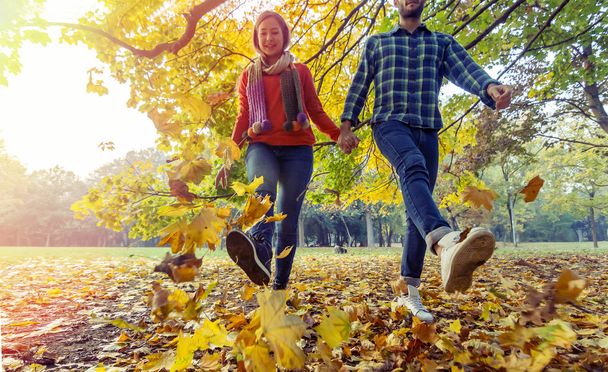 couple in love walking together in the middle of beautiful autumn trees - Foto, imagen