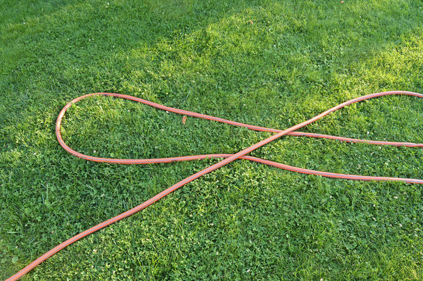 Лак с зеленой травой и резиновым покрытием для полива сада
 - Фото, изображение