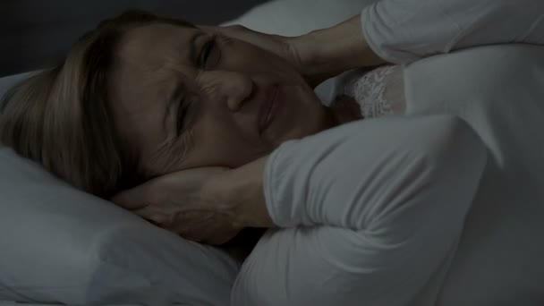Lady can't sleep due to terrible headache caused by noise at night, insomnia - Záběry, video