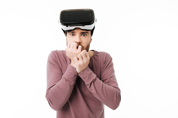 Muotokuva nuoresta miehestä, joka katsoo kameraan virtuaalitodellisuuslasit päässään valkoisella taustalla. Järkyttynyt poika käyttää visuaalista todellisuutta lasit eristetty
 - Valokuva, kuva
