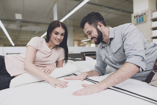 The couple came to a large mattress store to choose their own mattress. They lay down on one of them - 写真・画像