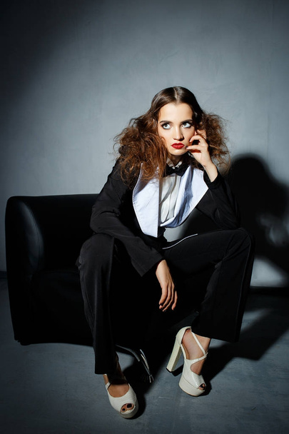 Brunette model posing on couch in the studio - Fotó, kép