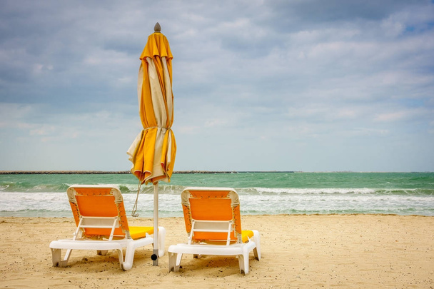Spiaggia vuota con poltrone e ombrellone
  - Foto, immagini