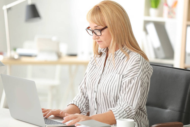 mature woman working on laptop - Фото, изображение