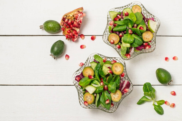 Свіжий салат з огірками, фейхоа, гранатом та листям салату
 - Фото, зображення