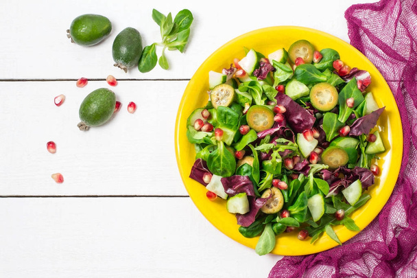 Ensalada fresca con pepinos, feijoa, granada y hojas de ensalada
 - Foto, imagen