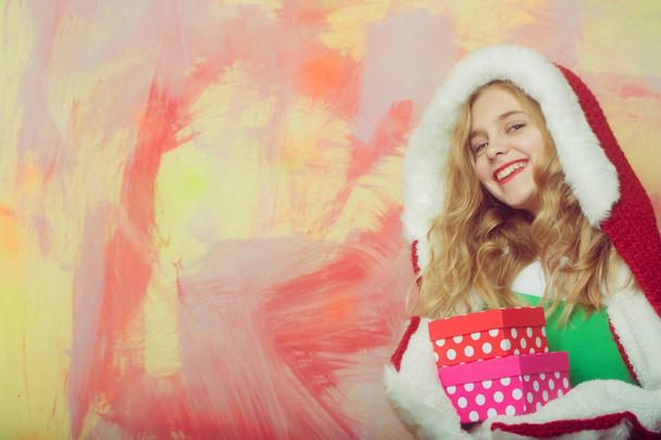 Happy girl in red santa fur hood with gift boxes - 写真・画像