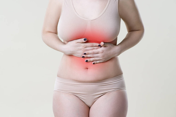 Woman with abdominal pain, stomachache on beige background - Foto, afbeelding