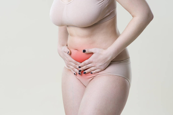 Woman with abdominal pain, stomachache on beige background - Valokuva, kuva