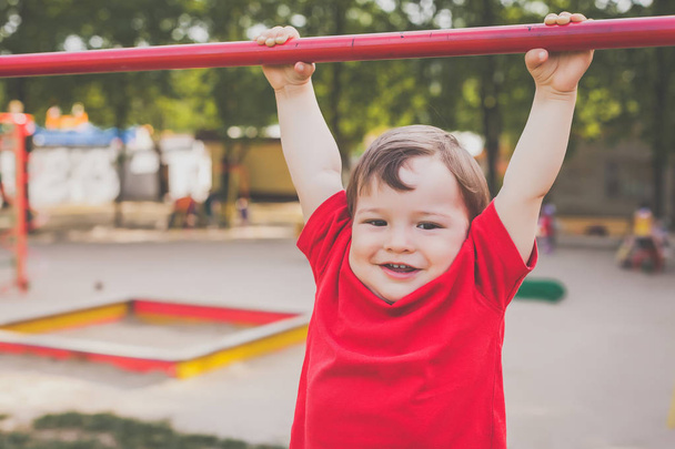 portrait of cute boy smiling and playing on playground - Zdjęcie, obraz