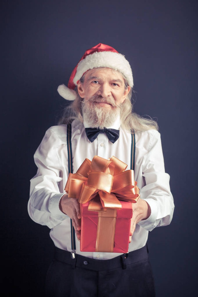 Santa Claus in white shirt with gift box in hands. - Фото, зображення