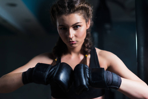 Молода боксерська дівчина носить боксерські рукавички перед тренуванням
. - Фото, зображення