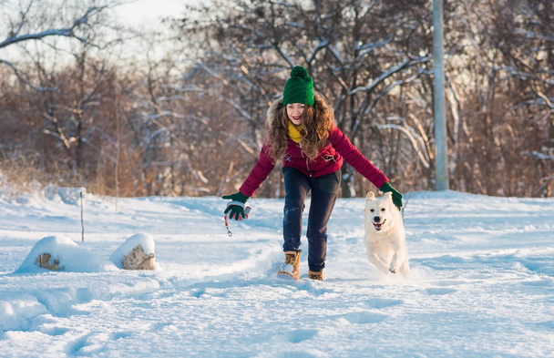 mladá žena vhodné s zlatý retrívr na zimní procházce. - Fotografie, Obrázek