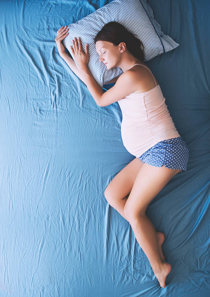 Pregnant woman relaxing or sleeping at bed.  - Photo, image