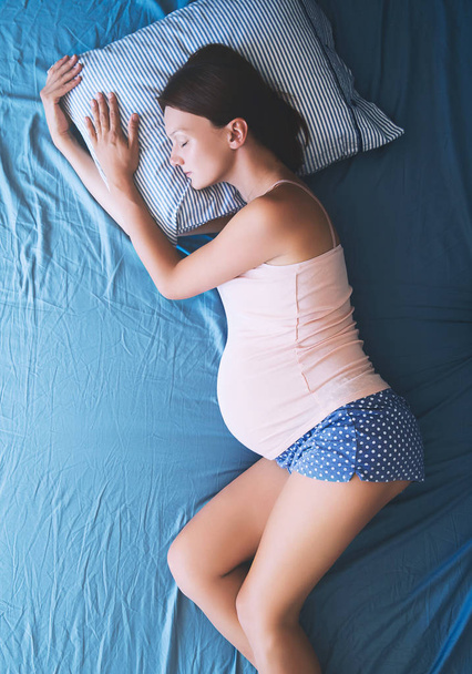 Femme enceinte se relaxant ou dormant au lit
.  - Photo, image