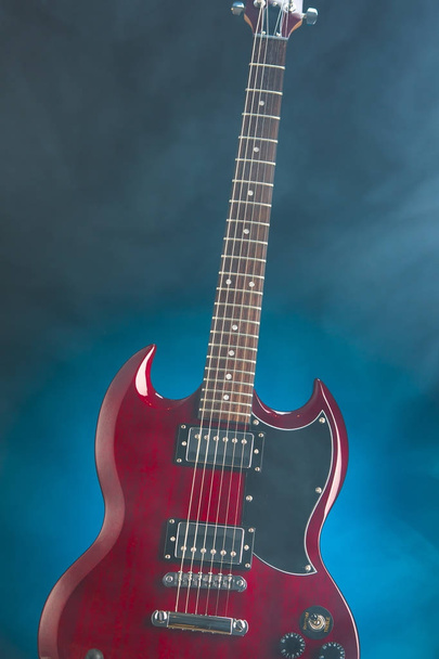 електрична гітара в диму, синій фон
 - Фото, зображення