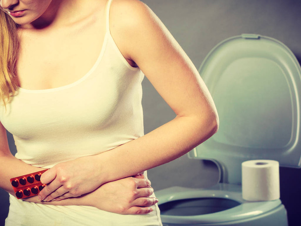Woman suffer from belly pain holds pills in toilet - Φωτογραφία, εικόνα