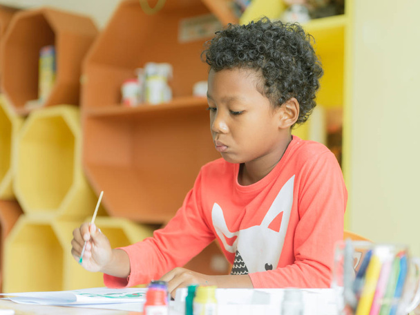 menino americano fazer casa usava lápis de cor de desenho na sala de aula do jardim de infância, biblioteca pré-escolar e conceito de educação infantil, imagens de estilo de efeito vintage
. - Foto, Imagem