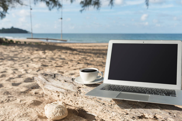 Dizüstü bilgisayar ve bir fincan kahve deniz görüntülemek - Fotoğraf, Görsel