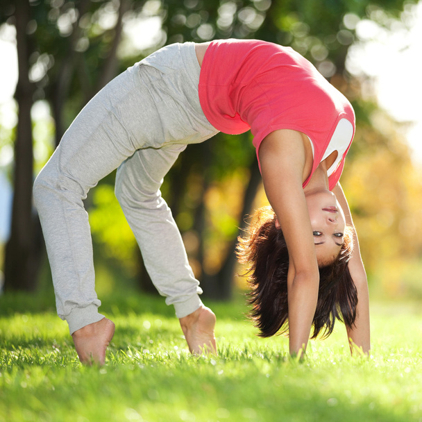Pretty woman doing yoga exercises in the park - Foto, Imagem