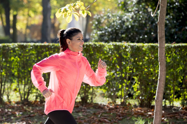 atrakcyjny i szczęśliwy runner Kobieta w jesieni sportowej uruchomiona i szkolenia na jogging treningu na świeżym powietrzu w parku miejskim - Zdjęcie, obraz