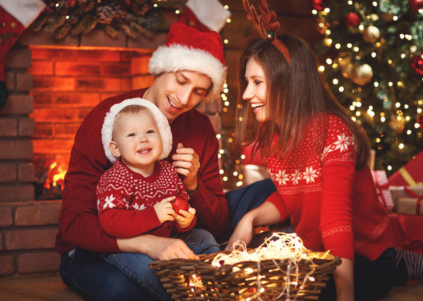happy family mother father and baby at christmas tree at home - Фото, изображение