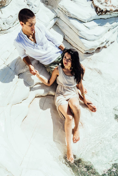 恋人の若いカップルは、白い岩の近くの美しい透明な水にバカンス - 写真・画像