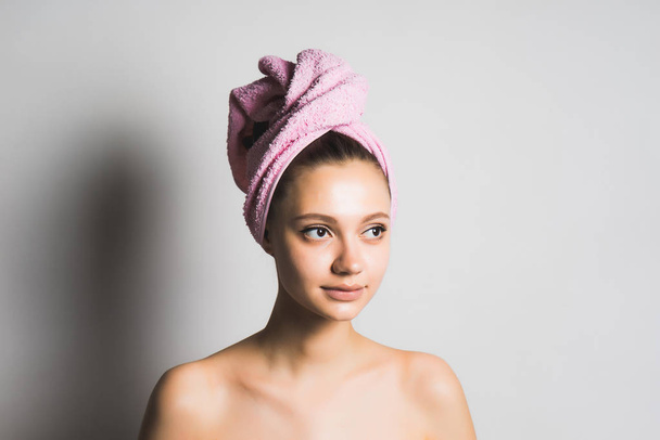 beautiful cute girl with clean skin, with a pink towel on her head posing, looking away - Foto, Imagen