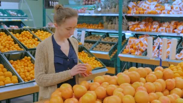 Frau kauft frische Grapefruits im Lebensmittelgeschäft - Filmmaterial, Video
