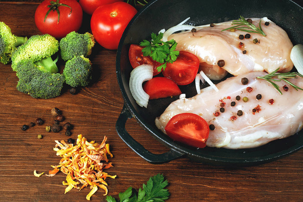 Сирі курячі грудки з овочами в чавунній сковороді. приготування їжі
 - Фото, зображення