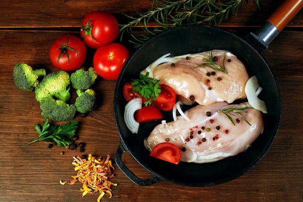Сирі курячі грудки з овочами в чавунній сковороді. приготування їжі
 - Фото, зображення
