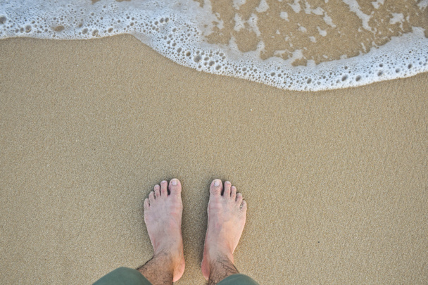 feet with wave on sandy beach top view - Photo, Image
