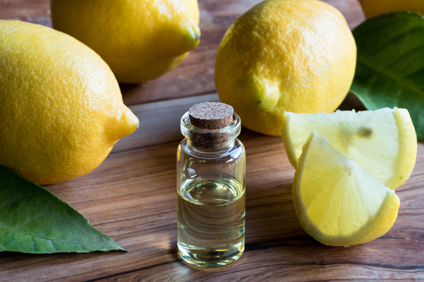 A transparent bottle of lemon essential oil with lemons in the b - Foto, immagini