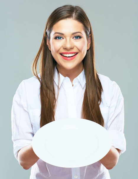 smiling businesswoman holding empty white plate in front  - Zdjęcie, obraz