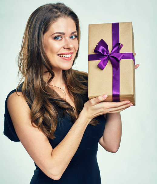 Smiling woman in black evening dress holding gift box. - Fotó, kép