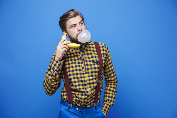 Ο άνθρωπος χρησιμοποιώντας μπανάνα ως ένα τηλέφωνο  - Φωτογραφία, εικόνα