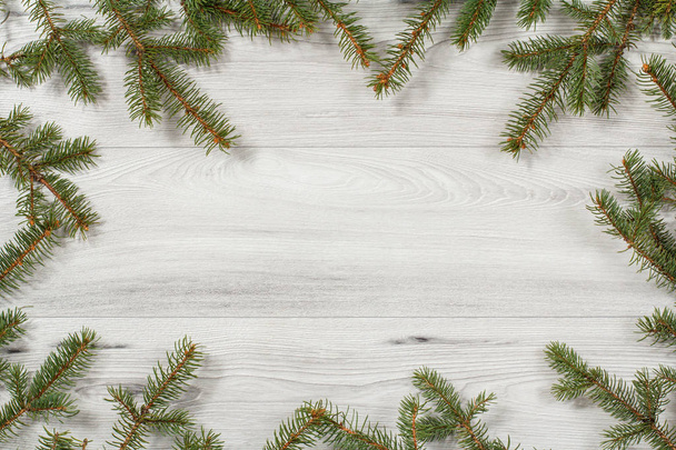 Frame from natural branches of fir tree on wooden background - Photo, Image