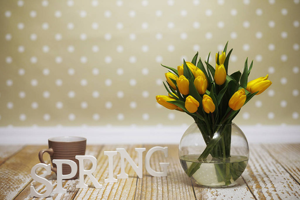 ein Strauß gelber Tulpen in einer Vase auf dem Boden. ein Geschenk an ein w - Foto, Bild